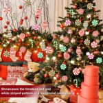 A cluster of red, white, and green striped wooden candy cane ornaments hanging from a Christmas tree branch.