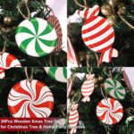 A cluster of red, white, and green striped wooden candy cane ornaments hanging from a Christmas tree branch.