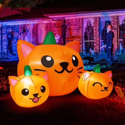 A 5-foot long Halloween inflatable featuring three orange and green pumpkin cat heads with bright white LED lights, set up ou