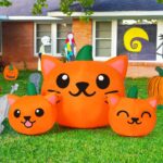 A 5-foot long Halloween inflatable featuring three orange and green pumpkin cat heads with bright white LED lights, set up ou
