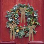 A close-up view of multiple light brown velvet ribbon bows, some hanging on a Christmas tree with soft, blurred lights in the
