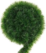 A long, lush green tinsel Christmas garland, non-lit, draped over a mantelpiece with a fireplace below.