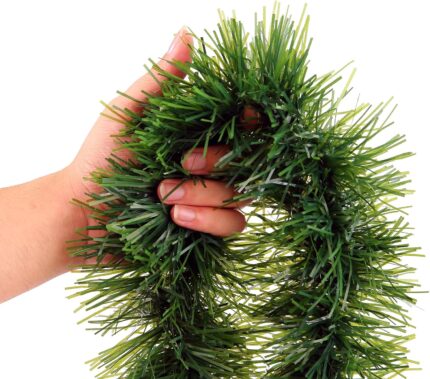 A long, lush green tinsel Christmas garland, non-lit, draped over a mantelpiece with a fireplace below.