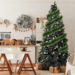 A long, lush green tinsel Christmas garland, non-lit, draped over a mantelpiece with a fireplace below.