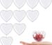 A group of ten clear plastic heart-shaped ornaments, some open to show their fillable design, ready for crafting.
