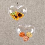 A group of ten clear plastic heart-shaped ornaments, some open to show their fillable design, ready for crafting.