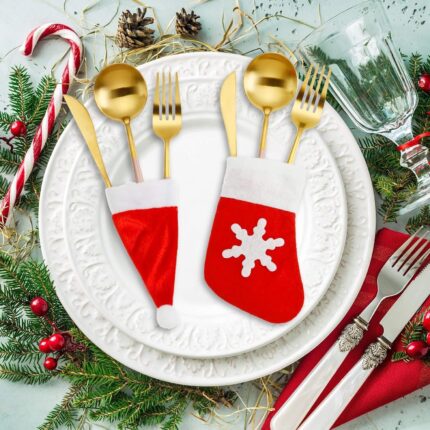 Close-up of red and white non-woven Christmas mini Santa hats and stocking silverware holders on a holiday table.