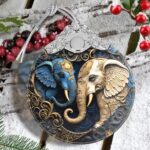 A close-up of a Touber elephant stained glass Christmas ornament hanging from a tree branch, showcasing its vibrant colors.