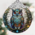 A close-up of a Touber stained glass owl Christmas ornament with intricate details and vibrant colors, hanging by a ribbon.