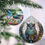 A close-up of a Touber stained glass owl Christmas ornament with intricate details and vibrant colors, hanging by a ribbon.